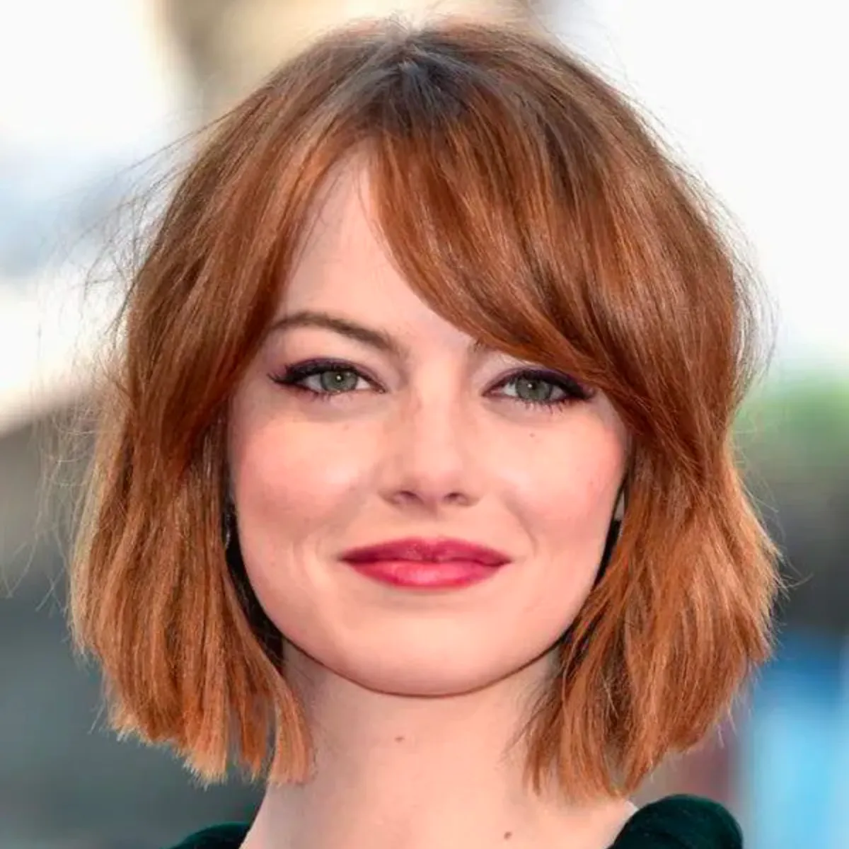La imagen muestra un corte bob con puntas ligeramente desordenadas y un flequillo suave que enmarca el rostro. El cabello tiene un tono castaño rojizo con un acabado brillante, aportando un aire fresco y juvenil. Este estilo es perfecto para quienes buscan un look elegante y moderno, con un toque desenfadado. Es un corte ideal para destacar las facciones de la cara con un estilo cómodo y de fácil mantenimiento.