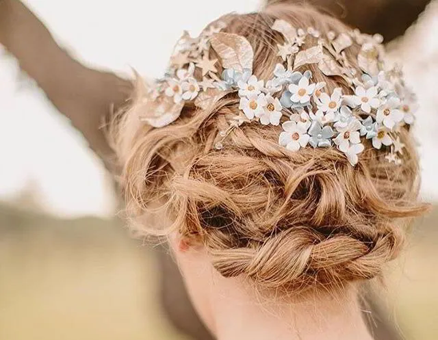 Recogido bajo con detalles florales delicados, ideal para un look romántico y fresco en bodas o eventos al aire libre